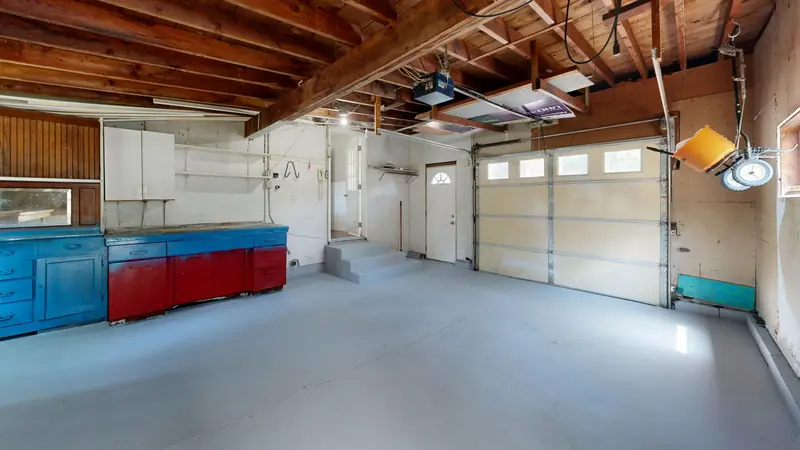 Empty garage with open space and colorful storage cabinets