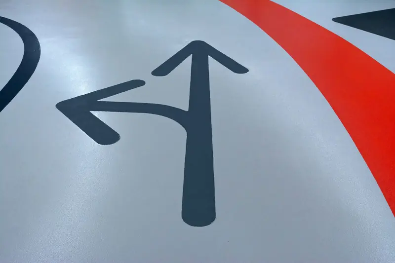 Close-up view of painted arrows on a parking garage floor indicating direction