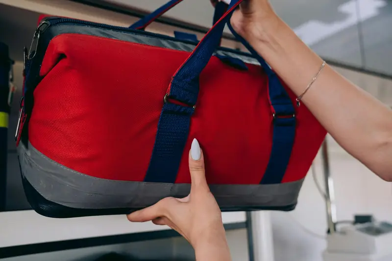 A paramedic securing a red emergency medical bag on a shelf inside an ambulance