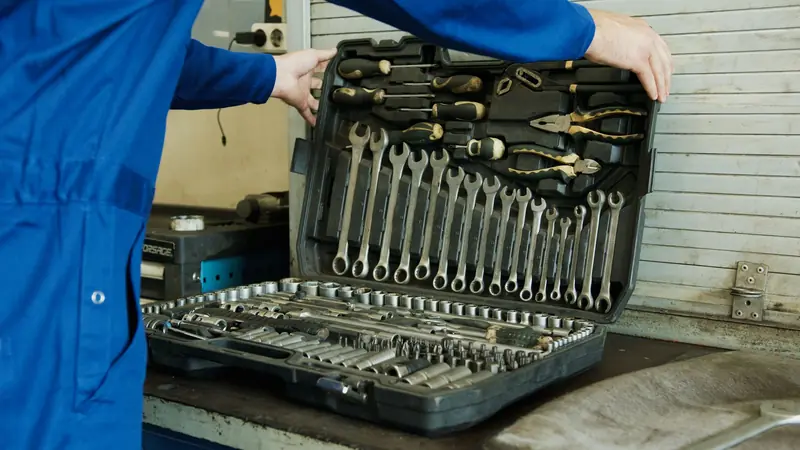 Mechanic organizing a comprehensive tool set for vehicle maintenance in a workshop setting