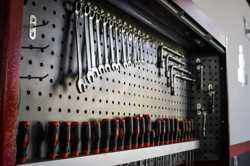A collection of hand tools neatly arranged on a pegboard for easy access and organization